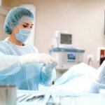 Female surgeon in sterile operating room preparing for a surgical procedure, emphasizing healthcare professionalism.